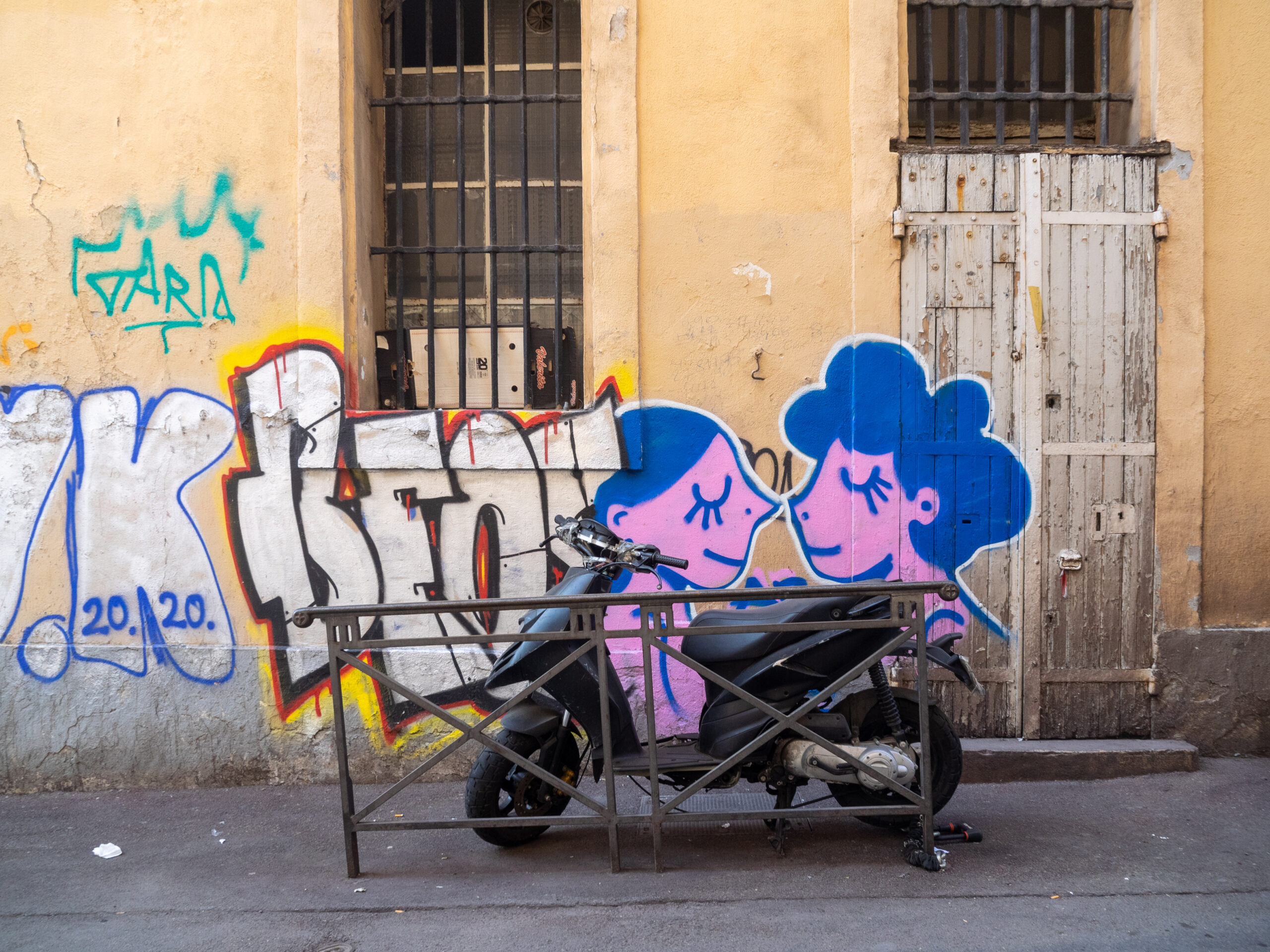 Photo d'un scooter garé devant un graffiti